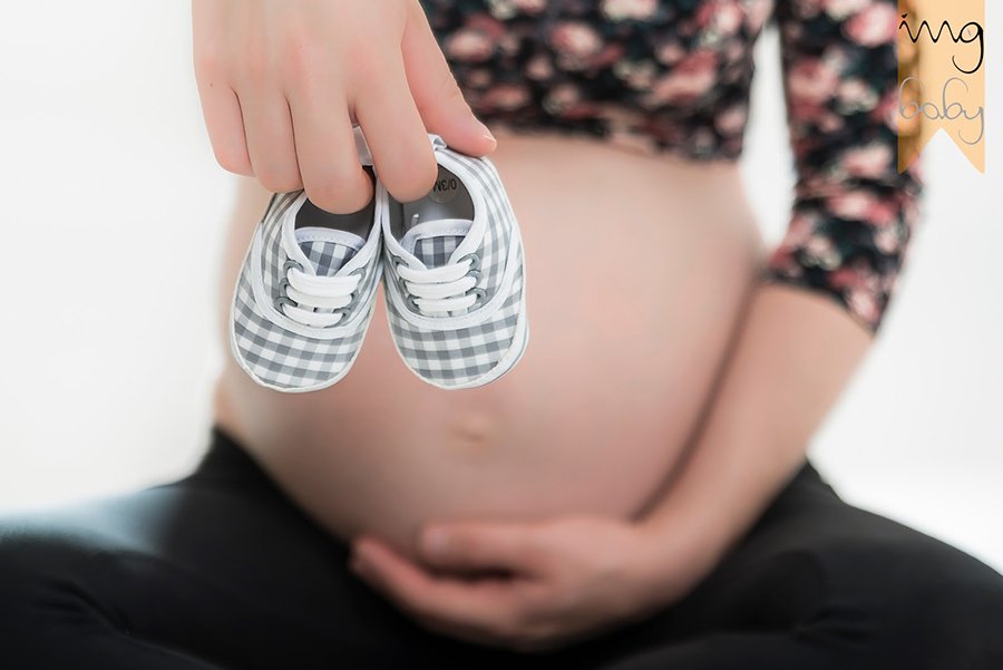 Detalle de zapatitos de bebe en fotografía para embarazadas